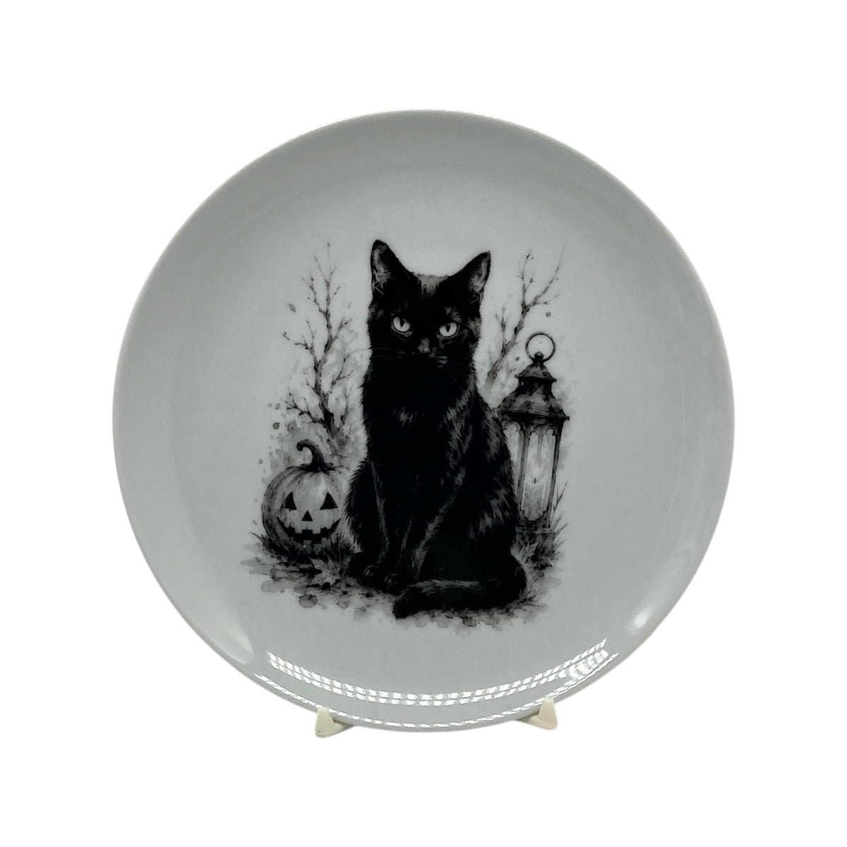 6.25 inch black cat Halloween coupe plate with jack-o’-lantern, lantern, bare branches and black-and-white spooky artwork