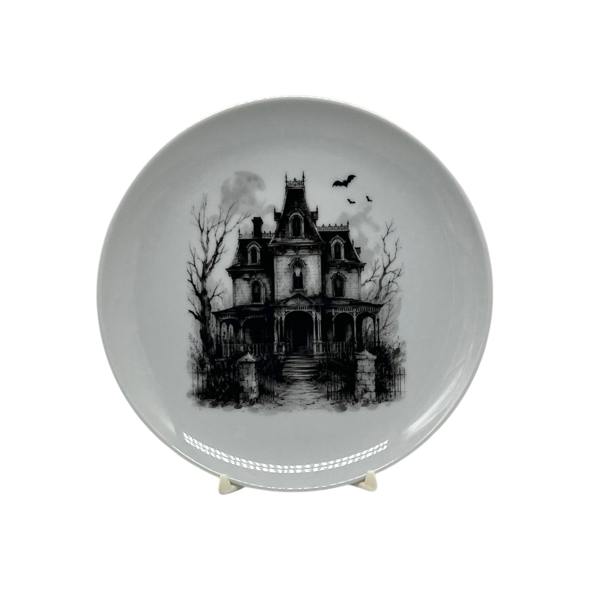 Haunted Manor 6.25 inch Halloween coupe plate with black-and-white Victorian haunted house, bare trees, wrought-iron gate and flying bats